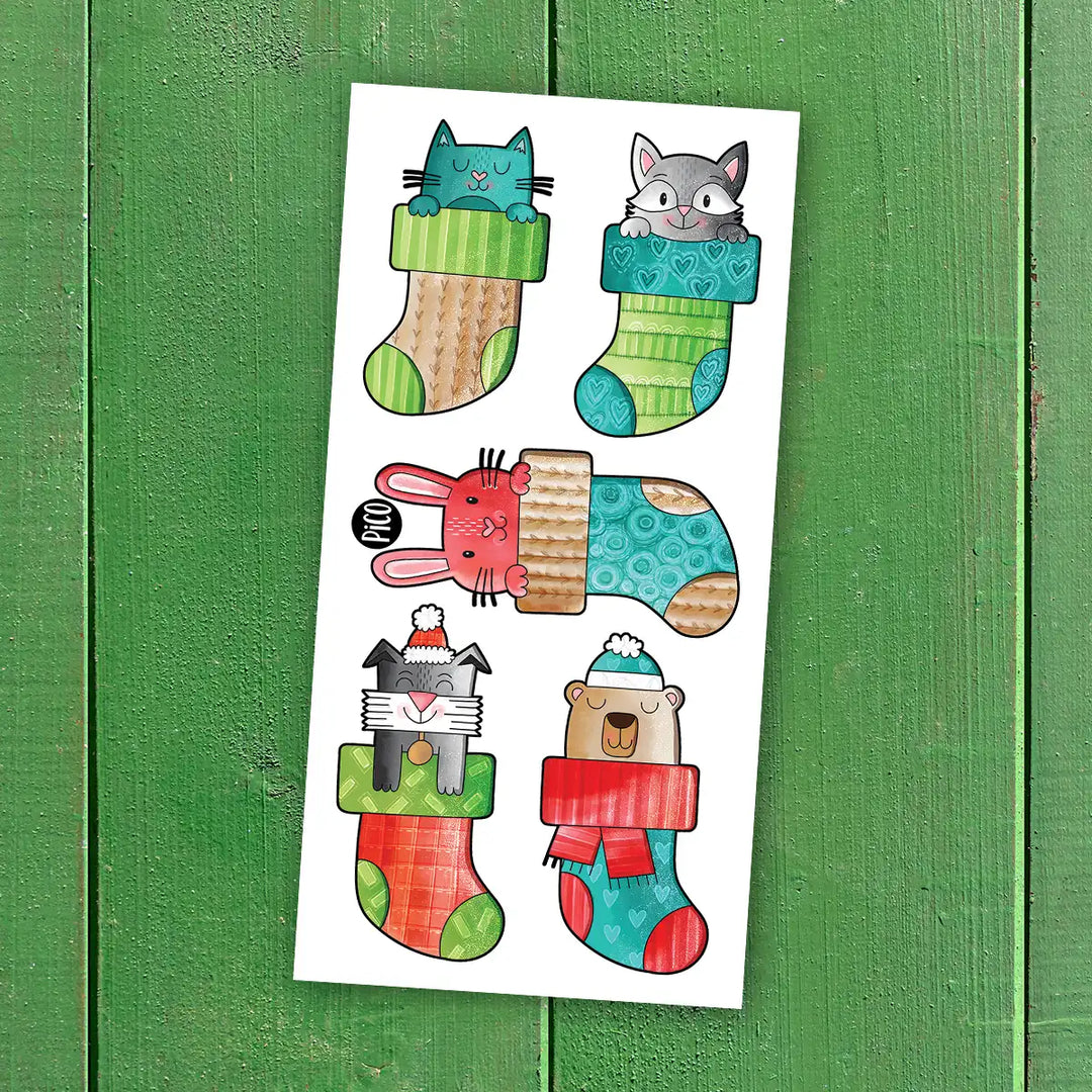 Tatouages temporaires bas de Noël avec animaux, motifs rouges et verts, style cartoon, pour enfants.
Christmas stocking temporary tattoos with animals, red and green cartoon designs for kids.