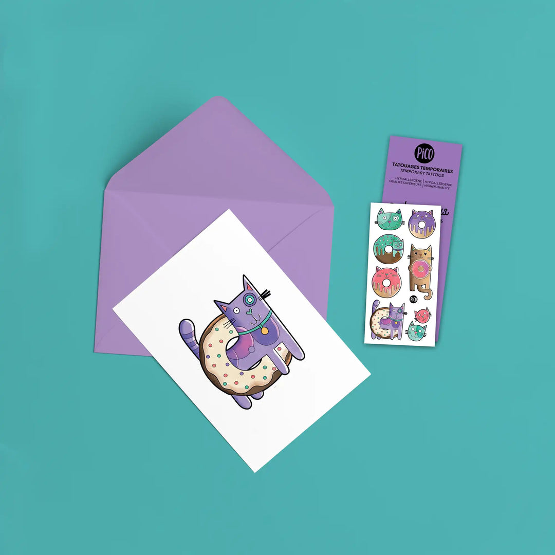Carte de souhait Chats Beignes accompagnée de son tatouage temporaire assorti, idéale en cadeau d'anniversaire pour enfant
Chats Beignes greeting card paired with its matching temporary tattoo, perfect birthday gift for kids
